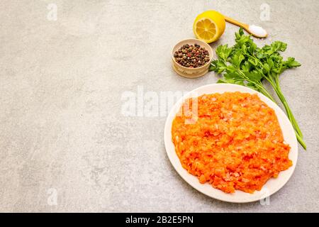 Roher, gemeißelter roter Fisch (Füllung) auf steinernem Grund. Zutat zur Herstellung von Fischkugeln, Kasserolen, Terrinen, Pate. Gewürze, Salz, Petersilie, Zitrone. Auf a Stockfoto