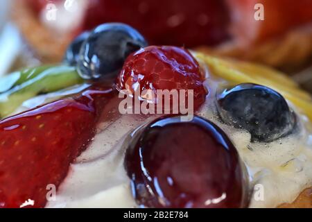 Detail der köstlichen verschiedenen Fruchtart mit Lichtreflexionen am Morgen auf der Glasur, die sie bedeckt Stockfoto