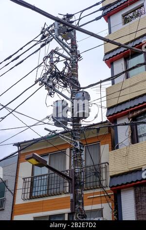 Typische ordentliche Strom- und Versorgungsleitungen in Tokio, Japan. Stockfoto