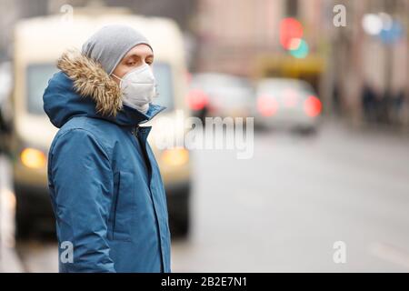 Der Kranke auf öffentlichen Verkehrsmitteln hält an, trägt eine Gesichtsmaske gegen übertragbare Infektionskrankheiten und als Schutz gegen die Grippe oder coron Stockfoto