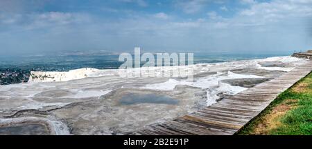 Ein Pfad in einem kleinen Park mit Aussichtsplattform auf dem weißen Pamukkale Berg in der Nähe von Travertinen an einem Sommermorgen. Stockfoto