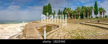 Ein Pfad in einem kleinen Park mit Aussichtsplattform auf dem weißen Pamukkale Berg in der Nähe von Travertinen an einem Sommermorgen. Stockfoto