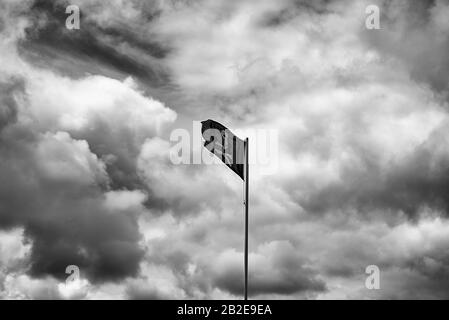 Mast eines Schiffes mit der Piratenflagge auf einem Fahnenmast Stockfoto