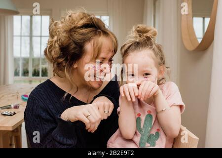 Mutter und Tochter ziehen dumme Gesichter beim Spielen zu Hause Stockfoto