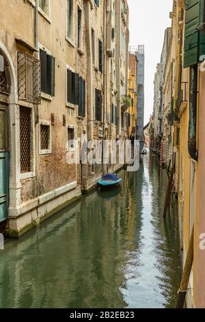 Venedig, ITALIEN - 02. August 2019: Eine der tausenden gemütlichen Ecken Venedigs an einem sonnigen Tag. Der schmale Kanal wird von der historischen Geschichte überragt Stockfoto