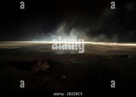 Abstrakter mars wie Gelände, schlammige Pfütze mit Wassertexturen, Felsen, starker Nebel Stockfoto