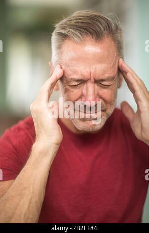 Reifer Mann mit einem Kopfschmerzen Foto Stockfoto