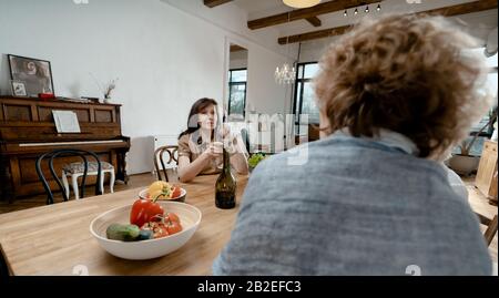 Alte Freunde Trafen Sich In Schönen, Stilvollen Apartments Und Trinkwein. Fröhliche, Lächelnde Brunette-Frau, Die Einen Toast Über Die Freundschaft Der Frau gibt. Natürliche Alterung Stockfoto