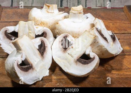 Champignon-Pilze auf einer Holzschnittplatte Stockfoto