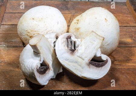 Champignon-Pilze auf einer Holzschnittplatte Stockfoto