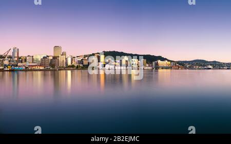 Wellington, neuseeländische Stadtgebäude und Skyline spiegelten sich bei Sonnenaufgang an einem perfekten Sommermorgen im Hafen wider. Wellington ist die Hauptstadt von NZ. Stockfoto