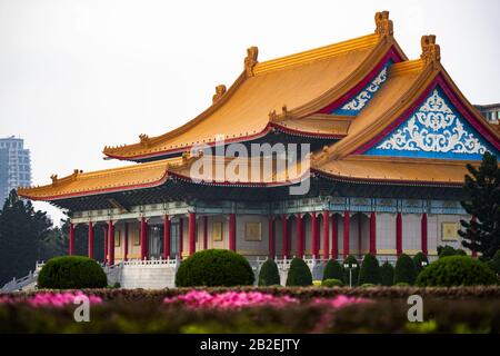 (Selektiver Fokus) Atemberaubender Blick auf Die Nationale Konzerthalle im Hintergrund und verschwommene Blumen im Vordergrund. Stockfoto