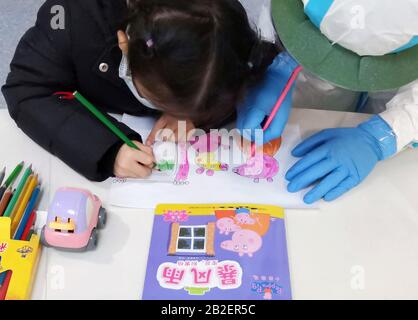 (200303) -- PEKING, 3. März 2020 (Xinhua) -- Foto mit Handy zeigt Krankenschwester Yang Liu, das ein Gemälde mit einem Kind zeichnet, das an einer Station im Wuhan Children's Hospital in Wuhan, der zentralen chinesischen Provinz Hubei, am 28. Februar 2020 mit einer neuartigen Coronavirus Pneumonie infiziert ist. Wegen der hohen Infektiosität des neuartigen Coronavirus müssen einige mit dem Virus infizierte Kinderpatienten im Krankenhaus leben, um die medizinische Behandlung ohne Begleitung ihrer Eltern und Familien zu erhalten. In der von der Epidemie heimtauften Stadt Wuhan bekommen 15 solcher Kinderpatienten die Behandlung in den Wuhan-Kindern Stockfoto