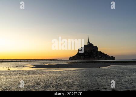 Sonnenuntergang am Mont-Saint Michel, während die Flut in der Normandie, Frankreich, kommt Stockfoto