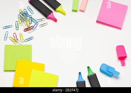 Haftnotizen mit Markierungen, farbigen Stiften und Büroklammern auf einem Tisch Stockfoto