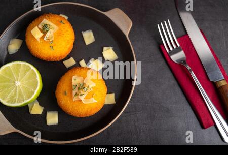 Hausgemachte Kroketten, gefüllt mit Käse mit Zitrone und einem Glas Rotwein. Stockfoto