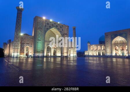Der zauberhafte Registan, das Herz der antiken Stadt Samarkand an einem verschneiten, regnerischen Abend mit Spiegelung in Puddel - Usbekistan Stockfoto