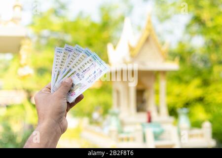 Sukhothai, THAILAND - 13. DEZEMBER 2019: Nahaufnahme der Thai-Frau, die Lotterie vor dem verwacklungsfreien Haus hält und Glück am Dez wünscht Stockfoto