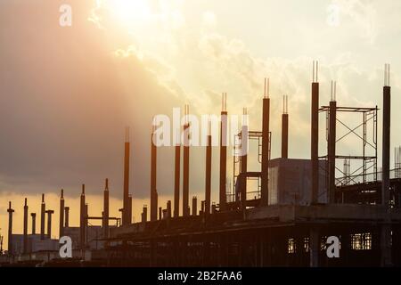 Silhouette des Bauarbeiters, der vor Ort für die Dachkonstruktion im Prozess des Hausbaus arbeitet Stockfoto