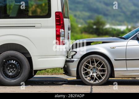 Autounfall mit zwei Autos auf der Straße. Die Rückseite des Wagens und die Vorderseite des Siver-Wagens werden durch einen Unfall beschädigt. Für das Reparaturkonzept des Autos Stockfoto