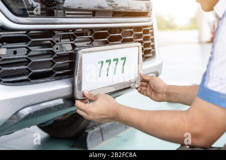 Techniker, der die Kennnummer des thailändischen Autotennzeichens im Service Center ändert Stockfoto