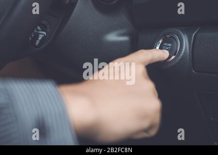 Hand of man drückt den Knopf Start/STOP Auto Motor im modernen Auto. Transportkonzept Stockfoto