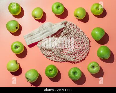 Null Abfall kreatives Konzept. Textile string Shopping Bag und appes Rahmen über helle orange hinterlegt. Von oben nach unten anzeigen. Hartes Licht Stockfoto