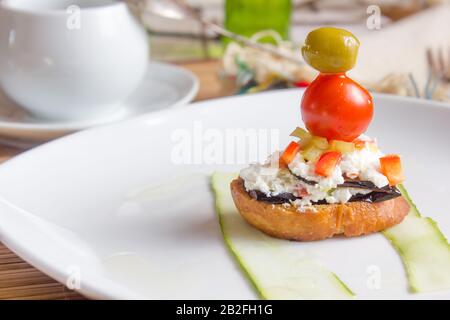 Leckere Bruschetta auf weißer Keramikplatte in Form eines Schiffes. Stockfoto