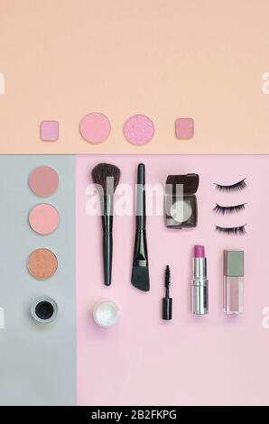 Bunte Kosmetik auf pinkfarbenem und gelbem Hintergrund. Make-up-Set. Flatlay-Hintergrund für Design Stockfoto