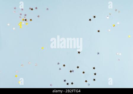 Golden funkelt Stars auf blauem pastellfarbenen Trendhintergrund. Festliche Kulisse für Ihre Projekte. Stockfoto