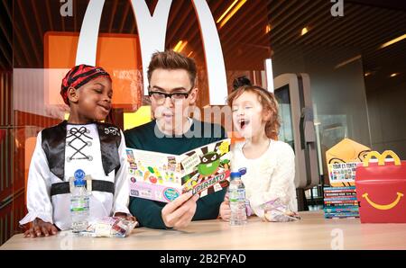 Redaktionelle VERWENDUNG NUR Kinderautor und Musiker Tom Fletcher liest den vierjährigen Zane-Ellis Yeboah (links) und Maisie Patey, da er als neuer McDonald's Happy Readers Ambassador zur Feier des Weltbuchtags in London vorgestellt wird. Stockfoto