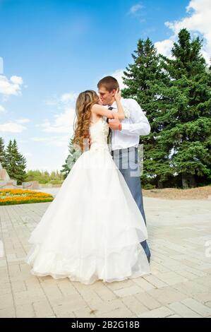 Hochzeitstag. Schöne Bride in weißem Kleid mit Bräutigam. Glückliches Küssen Paar Nach Der Heirat. Stockfoto