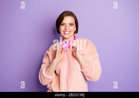 Foto von ziemlich lustigen erstaunlichen tausendjährigen Dame coole Ohrhörer Musik hören Jugend Lied Freude tragen Casual pink flauschigen Pullover isoliert violett Stockfoto