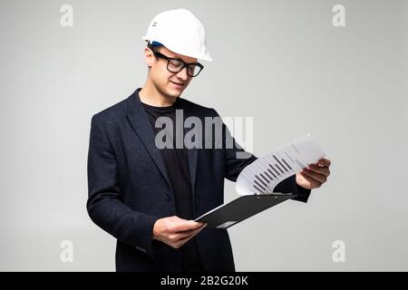 Porträt des selbstbewussten Architekten, der die Clipboard auf weißem Hintergrund hält Stockfoto