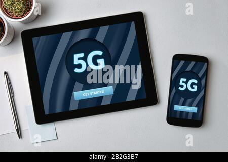 5G-Netzwerkkonzept auf Tablet- und Handybildschirm über grauem Tisch. Draufsicht Stockfoto