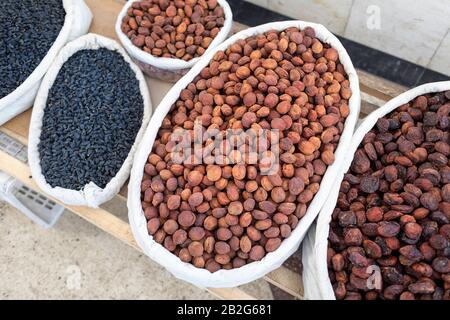 Rosinen, getrocknete Datteln und Aprikosen in Großbeuteln zum Verkauf auf dem Marktstand in Usbekistan, Zentralasien Stockfoto