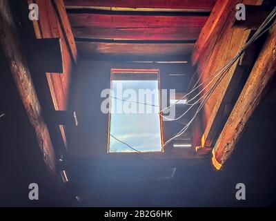 Altes Fenster mit Drähten. Blick vom Fenster auf den Himmel. Abstrakter Hintergrund im Vintage-Look Stockfoto