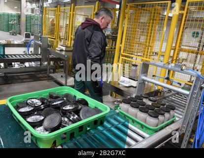 Torgau, Deutschland. Februar 2021. In der neuen Pilzfabrik des südkoreanischen Betreibers 'Mushraom Park' GmbH in Torgau steht ein Mitarbeiter in einer Abfüllanlage für künstliche Substanzen zur Fruchtbildung von Kräuterbesetzern. In großen automatischen Systemen wächst das Unternehmen zwei Edelpilze bis zu 10 Zentimeter Größe in mehreren tausend Zwölf-Zentimeter-Plastikflaschen, die mit beimpften Substraten gefüllt sind. Diese können nach 60 Tagen geerntet werden. Bis Ende des Jahres sollen rund 1560 Tonnen das Werk verlassen. Kredit: Waltraud Grubitzsch / dpa-Zentralbild / ZB / dpa / Alamy Live News Stockfoto