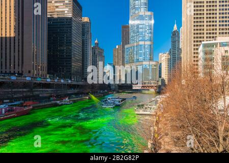 Chicago, USA - MAR 2019: Unerkennbare Menschen und Touristen auf der Yacht, die über den Chicago River Walk im Saint Patrick's Day mit grüner Farbe läuft Stockfoto