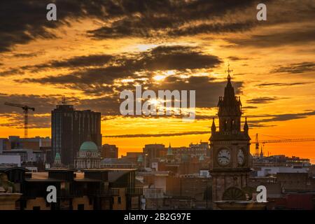 Sonnenuntergang über Belfast mit Albert Clock und Grand Central Hotel Stockfoto