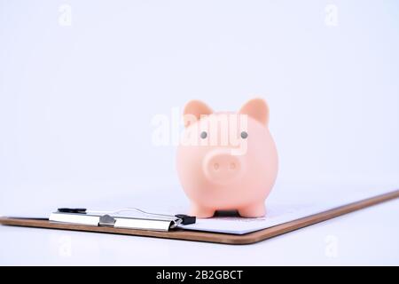 Finanzklage - Piggy Bank, wunderschönes rot-weißes Holzhausmodell auf weißem Hintergrund, spart Geld beim Kauf von Versicherungen, Nahaufnahme, Kopierplatz. Stockfoto