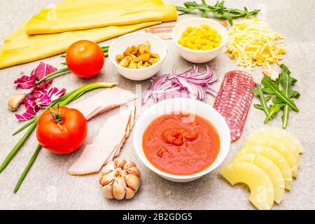 Rohe Zutaten für Pizza, Quiche, herzhafte Pastete. Background aus Kochstein. Stockfoto