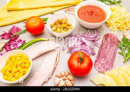 Rohe Zutaten für Pizza, Quiche, herzhafte Pastete. Background aus Kochstein. Stockfoto