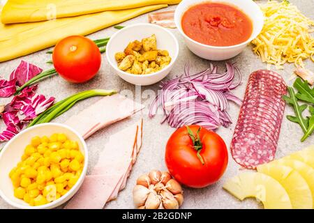 Rohe Zutaten für Pizza, Quiche, herzhafte Pastete. Background aus Kochstein. Stockfoto