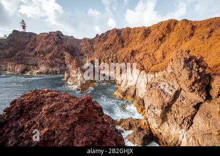 Schöne Landschaft an einer felsigen Küste mit gewelltem Ozean während eines Sonnenuntergangs. TeNo cape im Nordwesten der Insel Tena Stockfoto