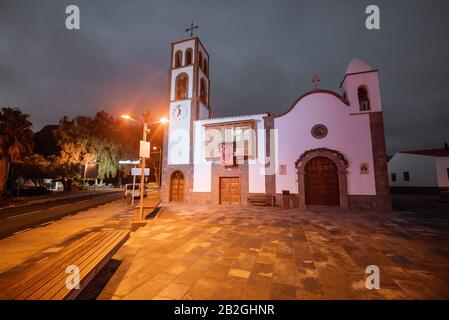 Nachtblick auf den zentralen Platz mit alter Kirche im Dorf Santiago del Teide im Nordwesten der Insel Tenera, Spanien Stockfoto