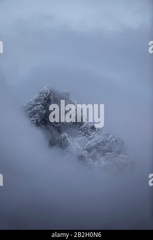 Mystischer Berg mit Neuschnee durch den Nebel in Jotunheimen, Norwegen Stockfoto