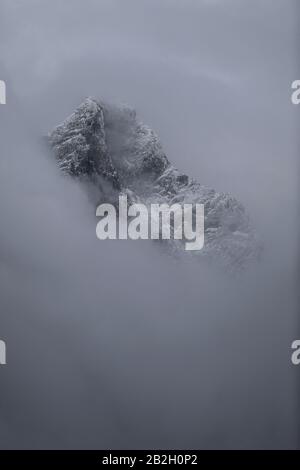 Mystischer Berg mit Neuschnee durch den Nebel in Jotunheimen, Norwegen Stockfoto