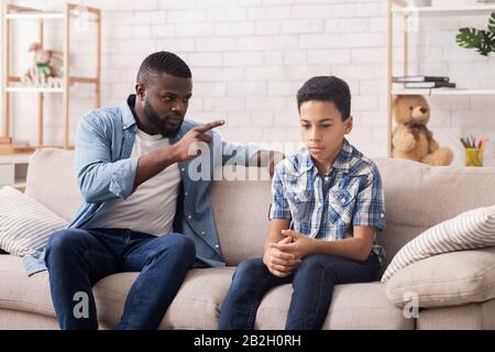 Gewalt Der Eltern. Wütend Black Father Schimpft Seinen Aufgebrachten Unschuldigen Sohn Stockfoto