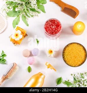 Spa- und Badezubehör mit Badesalzen und Kosmetikprodukten auf weißem Tisch. Wellness-Konzept lag vor Stockfoto